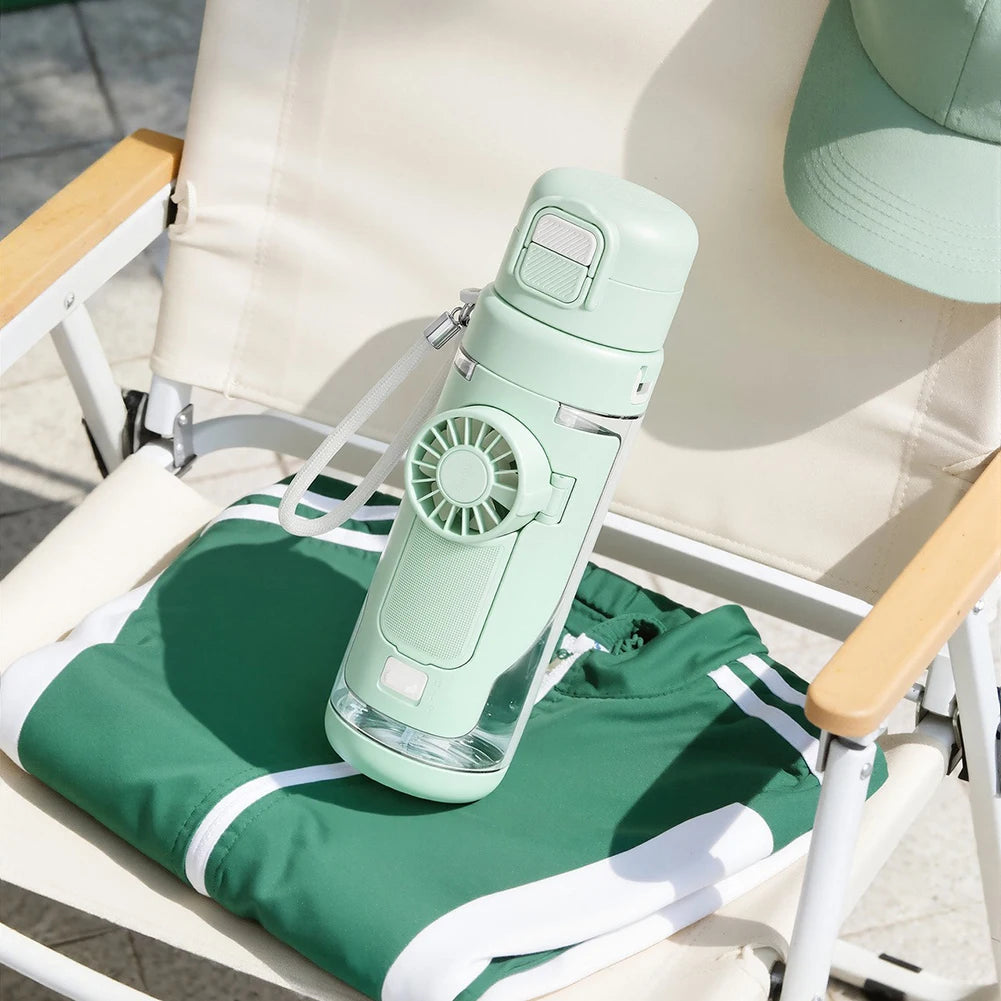 Green water bottle with built-in fan on a chair