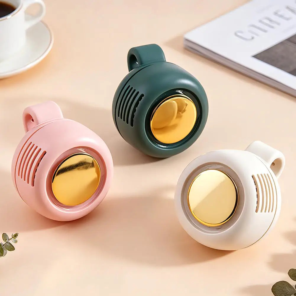 Three small round devices with gold centers on a beige surface, next to a cup of coffee and a book.